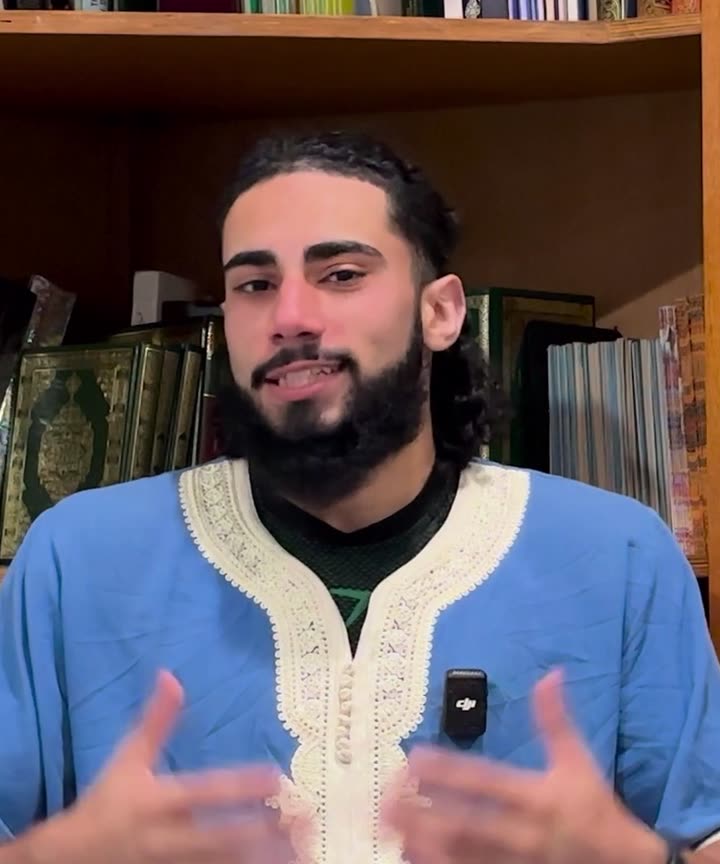 Hamza Aurangzeb, sitting in front of a bookshelf